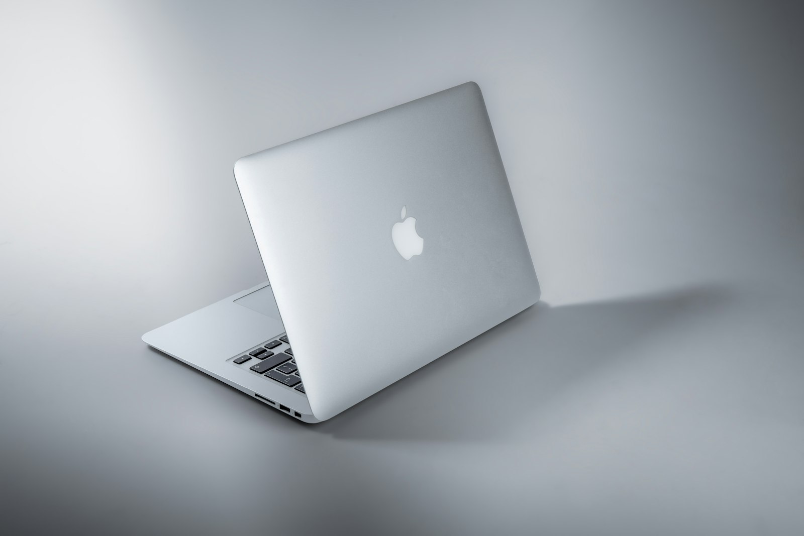 MacBook argenté posé sur une table claire, dans l'atelier Ideal.