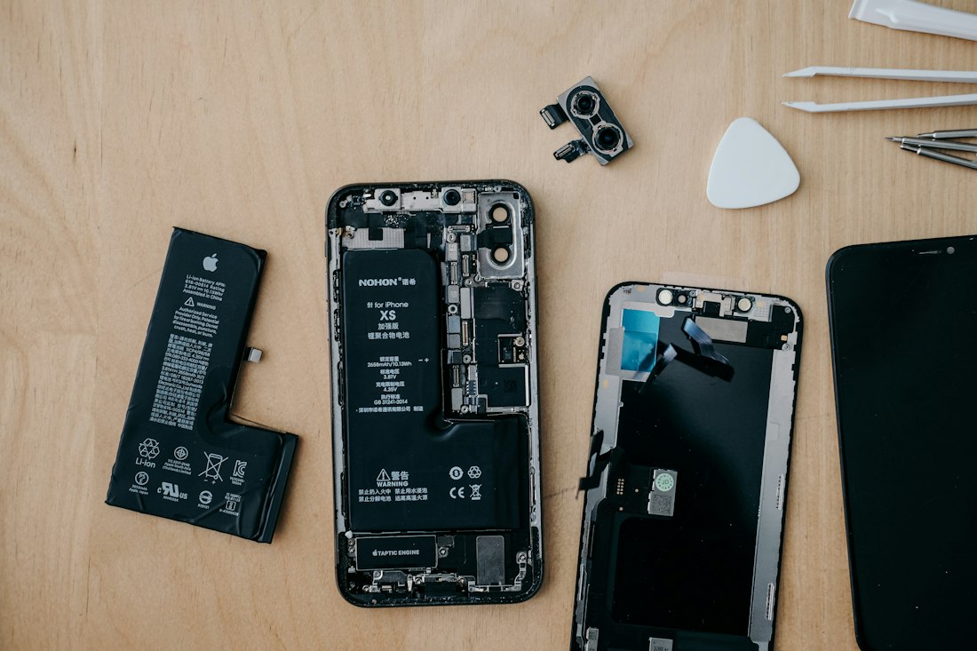 Châssis d'iPhone ouvert, nappes et batterie visibles.