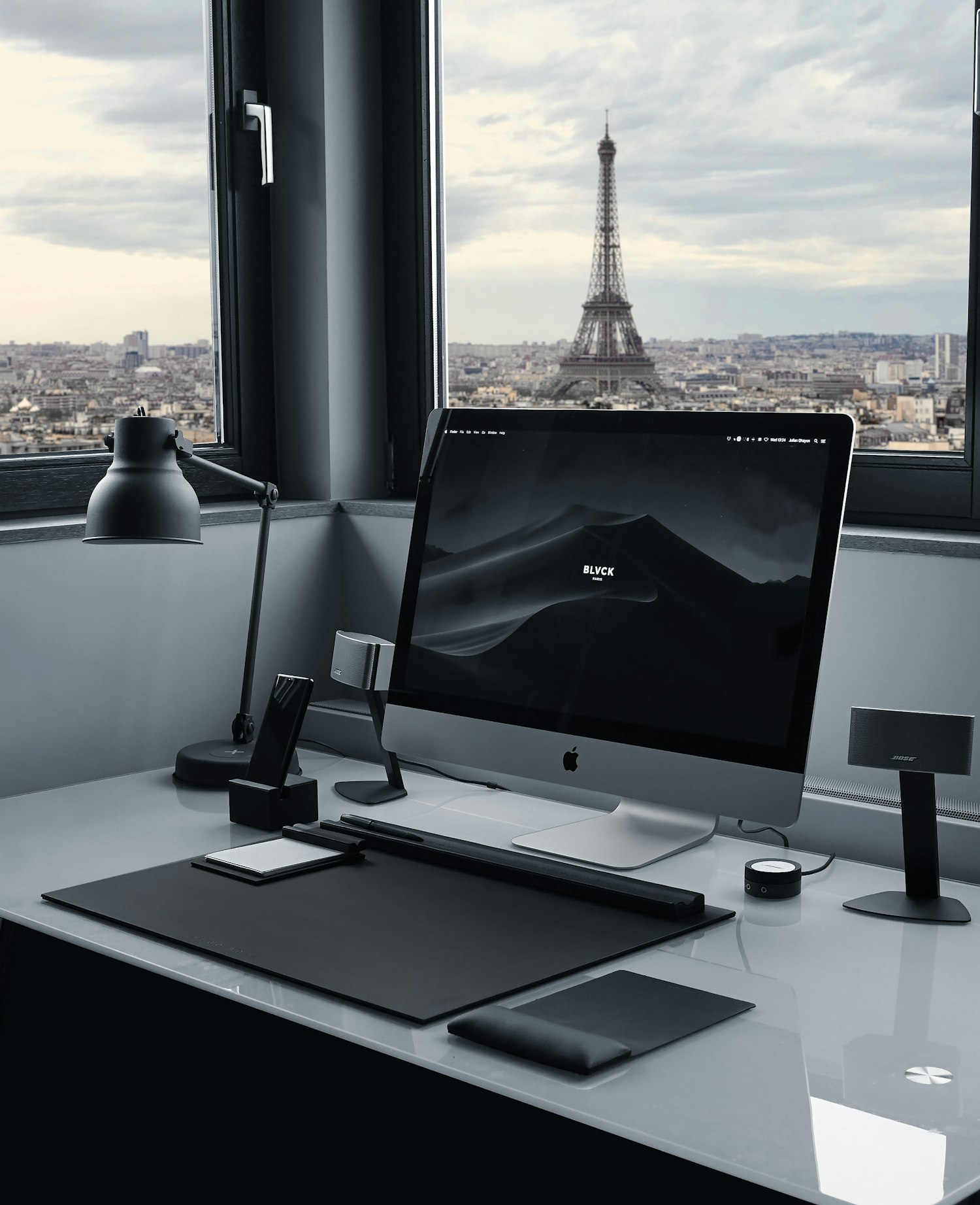 iMac argenté installé sur un plan de travail clair.